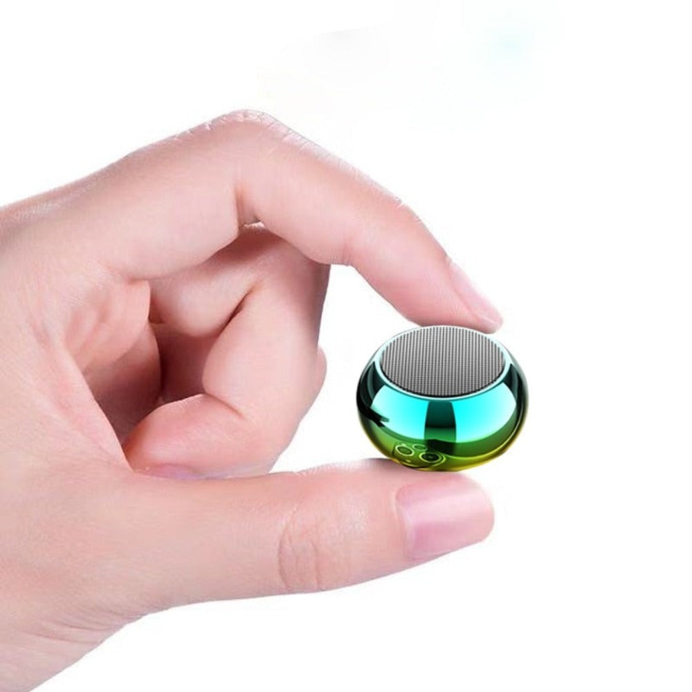 Hand holding a small, round, metallic object with a reflective surface on a white background.  Dragon Mini Speaker Colors - Multiple Color Options Available | Smart Glow Connect