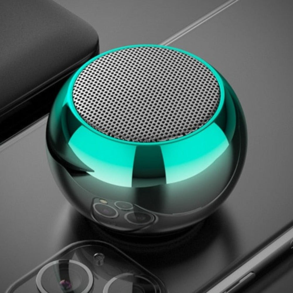 Turquoise portable speaker on a reflective surface. Mini Bluetooth Speaker - Pocket-Sized 3W Audio Device | Smart Glow Connect